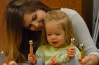 Mom, toddler girl play jingles together in music class
